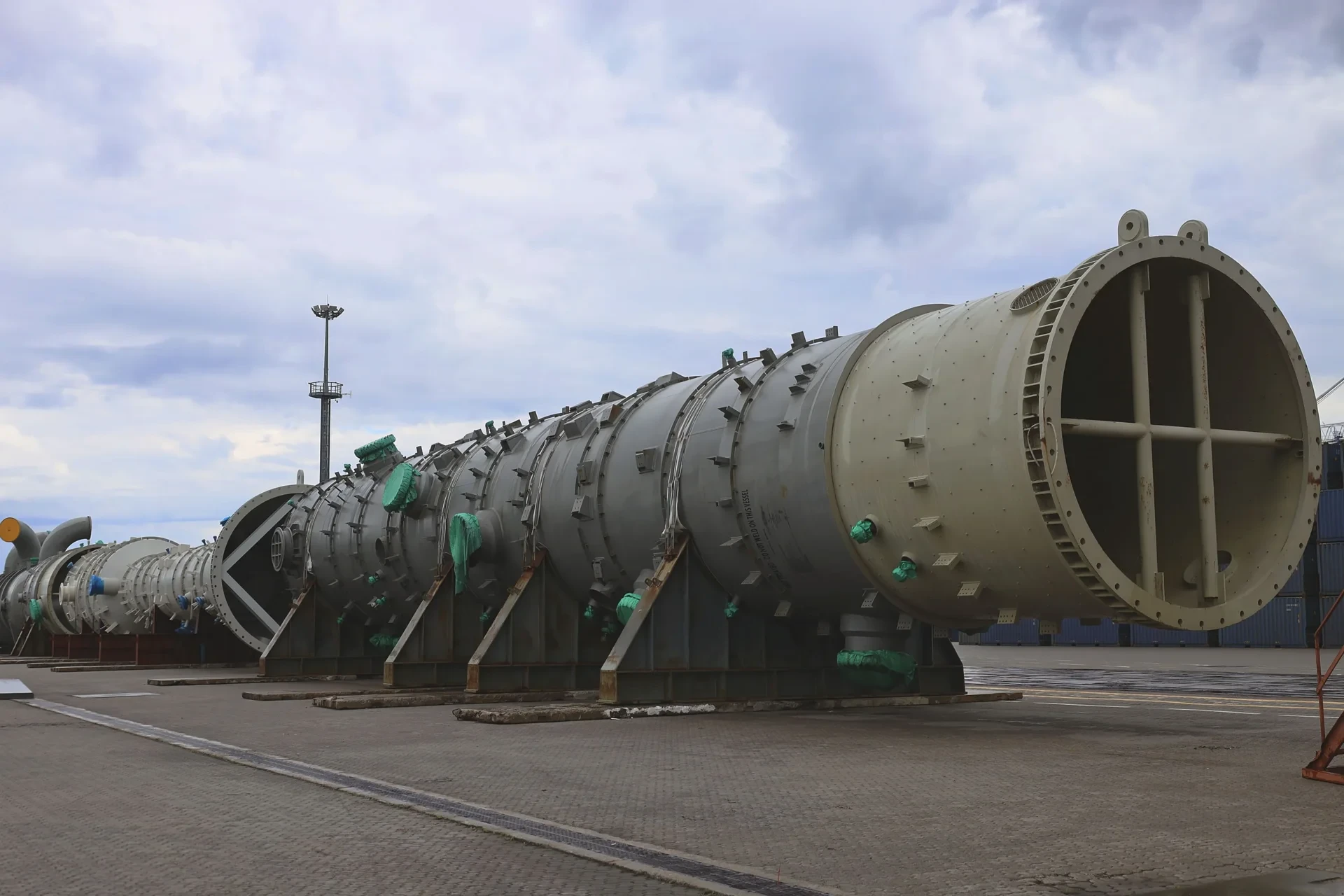 Oversized cylindrical equipment resting on supports on the quay at Bronka Port